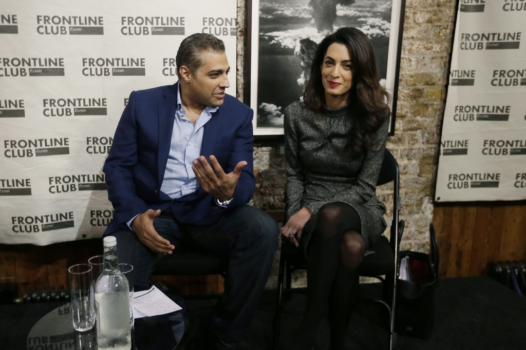 Former Al Jazeera bureau chief Mohamed Fahmy left with his lawyer Amal Clooney smile ahead of a talk at the Frontline Club in London Wednesday Oct. 7 2015