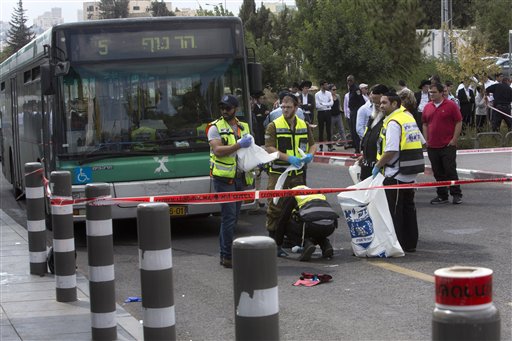 Israeli ZAKA emergency response members clean the scene of a stabbing attack in Jerusalem Thursday Oct. 8 2015. A Palestinian stabbed a Jewish seminary student in Jerusalem on Thursday as the Israeli prime minister barred all Cabinet ministers and law