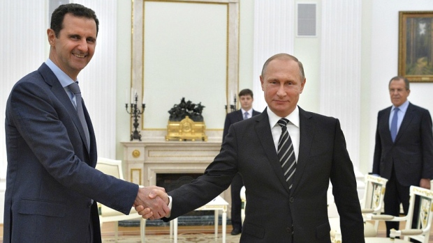 Russian President Vladimir Putin shakes hands with Syrian President Bashar al Assad during a meeting at the Kremlin in Moscow Russia