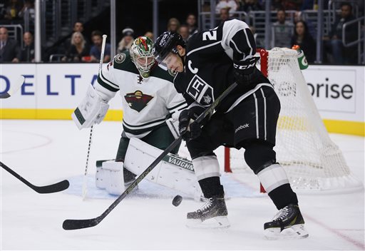 Minnesota Wild goalie Darcy Kuemper left looks to prevent Los Angeles Kings right wing Dustin Brown right from scoring during the second period of an NHL hockey game Friday Oct. 16 2015 in Los Angeles