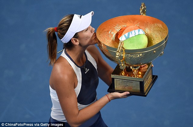 Garbine Muguruza kisses the trophy after overcoming a sluggish start to win the China Open