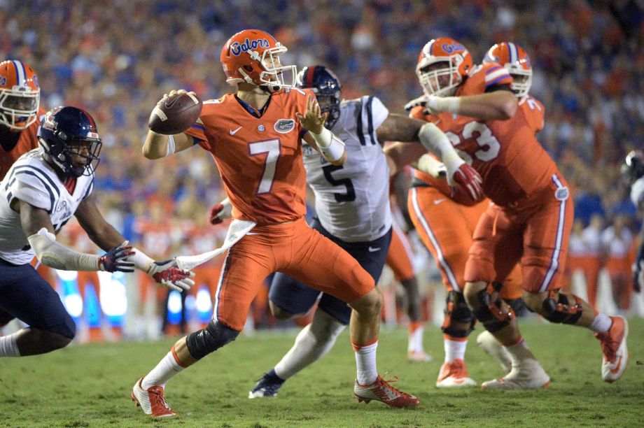 Florida quarterback Will Grier throws a pass between Mississippi linebacker C.J. Johnson left and defensive tackle Robert Nkemdiche during the first half of an NCAA college football game Saturday Oct. 3 2015 in Gainesville Fla. Florida won 3