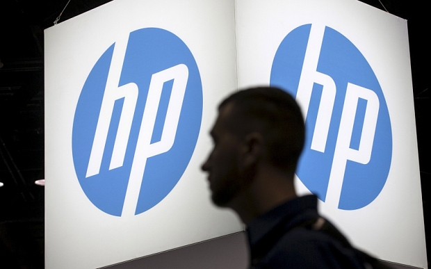 An attendee at the Microsoft Ignite technology conference walks past the Hewlett Packard logo in Chicago Illinois