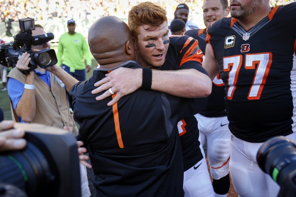 Bengals quarterback Andy Dalton center right hugs offensive coordinator Hue Jackson after Sunday's 27-24 come-from-behind win in overtime over Seattle in Cincinnati