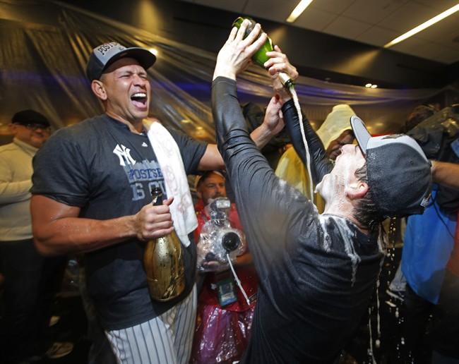 New York Yankees Alex Rodriguez left laughs as he watches teammate John Ryan Murphy chug champagne as the Yankees celebrated clinching a wild card berth in the playoffs with a 4-1 win over the Boston Red Sox in a baseball game in New York Thursday Oct