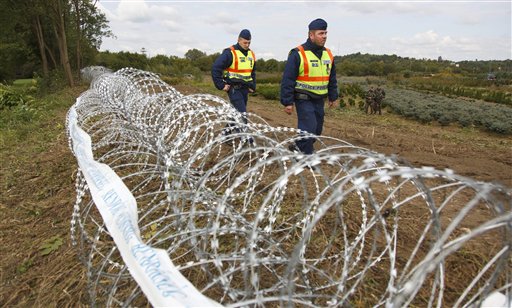 Hungarian police officers patrol the area at the temporary border fence positioned at the green border between Hungary and Croatia at Zakany 234 km southwest of Budapest Hungary Wednesday Sept. 30 2015