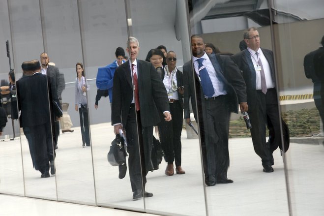 Attendees are reflected in a mirrored wall as they arrive for the IMF and World Bank annual meetings in Lima Peru Thursday Oct. 8 2015. The world's finance ministers and central bankers are in Lima for the joint annual meetings of the World Bank and