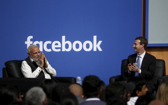 Indian Prime Minister Narendra Modi gives a'namaste, a gesture of greeting as Facebook CEO Mark Zuckerberg applauds on stage after a town hall at Facebook's headquarters in Menlo Park California