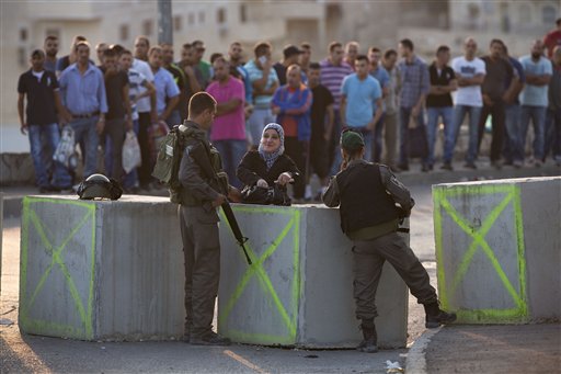 Israeli border police check Palestinian's IDs at a checkpoint as they exit the Arab neighborhood of Issawiyeh in Jerusalem Sunday Oct. 18 2015. Palestinian assailants carried out a series of five stabbing attacks in Jerusalem and the West Bank