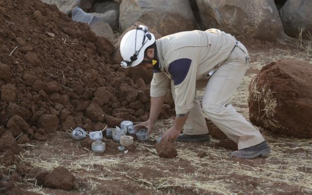 A civil defence member gathers unexploded cluster bomblets that activists say were fired by the Russian air force at Maasran town in the southern countryside of Idlib Syria