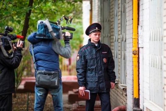 Members of the media film as a Russian policeman stands at an entrance of the building where homemade explosives were found in an apartment in Moscow Russia Monday Oct. 12 2015. Russia’s counterterrorism agency says it has raided a Moscow apartment