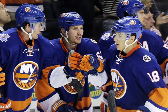 CORRECTS TO OCT. 12 NOT 11 New York Islanders center Ryan Strome is congratulated by teammates Brock Nelson left and Casey Cizikas center after scoring a power-play goal in the first period of an NHL hockey game against the Winnipeg Jets