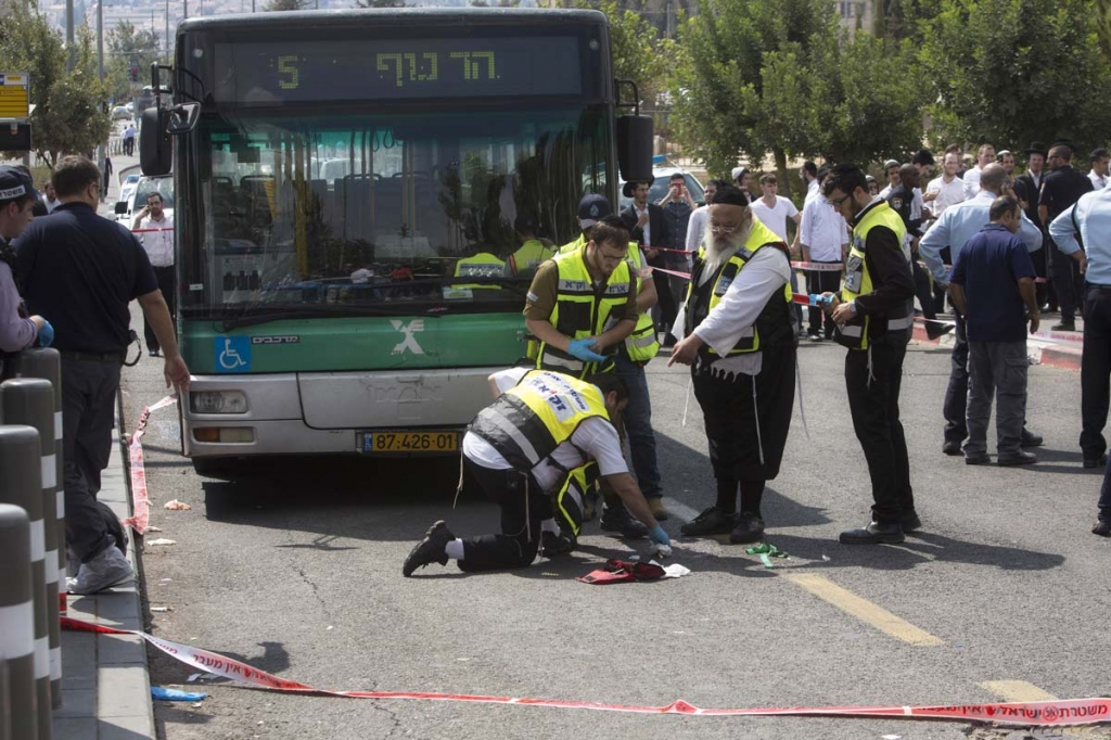 Israeli ZAKA emergency response members clean the scene of a stabbing attack in Jerusalem Thursday Oct. 8 2015