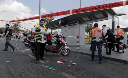 Israeli emergency personnel stand at the scene of a stabbing in Jerusalem on Oct. 8