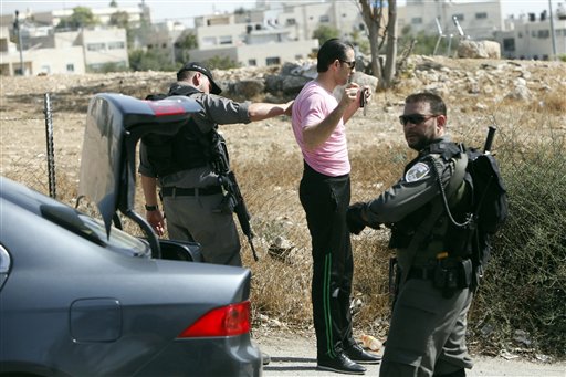 Israeli border police search a man driving out of the Palestinian neighborhood of Jabal Mukaber in Jerusalem Wednesday Oct. 14 2015. Israel erected checkpoints and deployed several hundred soldiers in the Palestinian areas of the city Wednesday as it