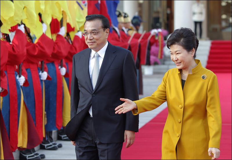 South Korean President Park Geun-Hye right and Chinese Premier Li Keqiang left inspect an honor guard during a welcoming ceremony at the presidential Blue House on today in Seoul South Korea