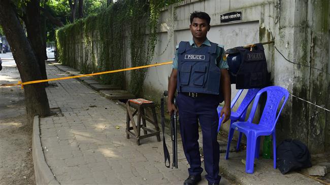 A Bangladeshi police officer stands guard at the site where an Italian charity worker was shot dead by attackers in Dhaka