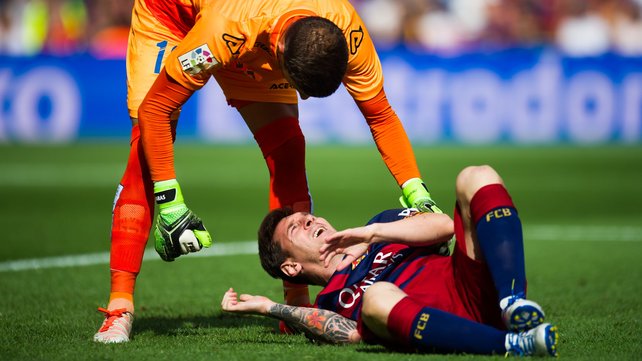 Javi Varas of UD Las Palmas helps the injured Lionel Messi