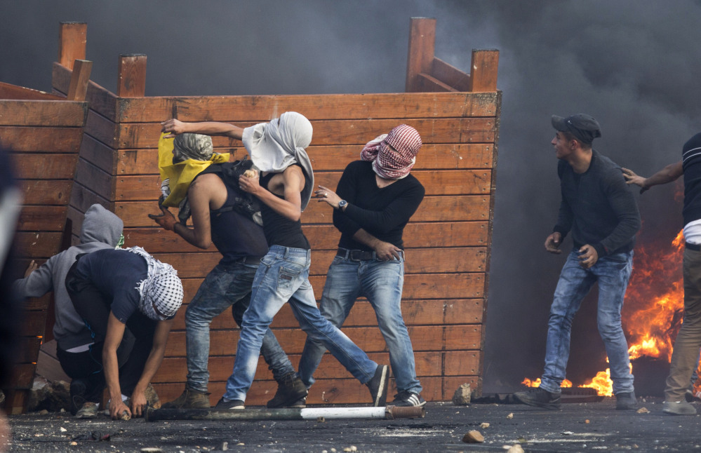 Palestinian protesters throw stones at Israeli troops on the West Bank on Friday. The death toll was the highest in the enclave since last year’s war between Hamas and Israel