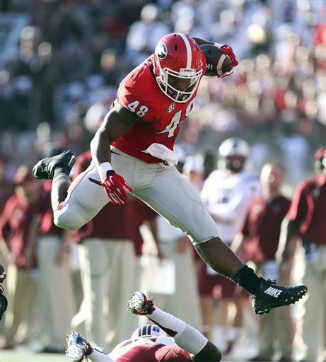 Georgia fullback Quayvon Hicks leaps over a South Carolina defender as he runs for a first down after making a catch in the first half of an NCAA college football game in Athens Ga. In Athens Georgia the