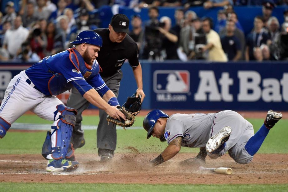 Toronto Blue Jays catcher Russell Martin left attempts to tag Texas Rangers Rougned Odor right who scores during the 14th inning of baseball Game 2 of the American League Division Series in Toronto Friday Oct. 9 2015. (Nathan Denette  The Canadian