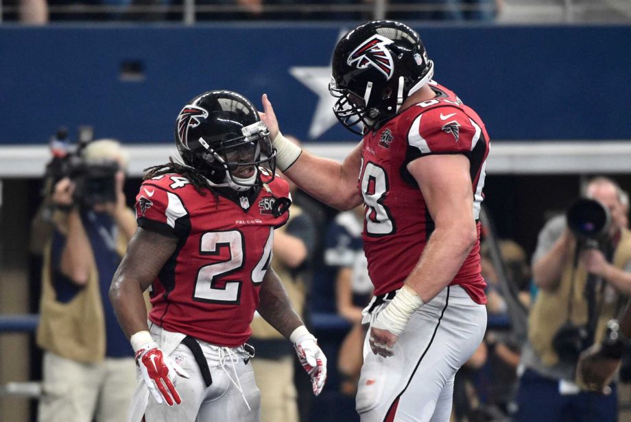 Atlanta Falcons Devonta Freeman and Mike Person right celebrate a touchdown by Freeman during the second half of an NFL football game against the Dallas Cowboys on Sunday Sept. 27 2015 in Arlington Texas