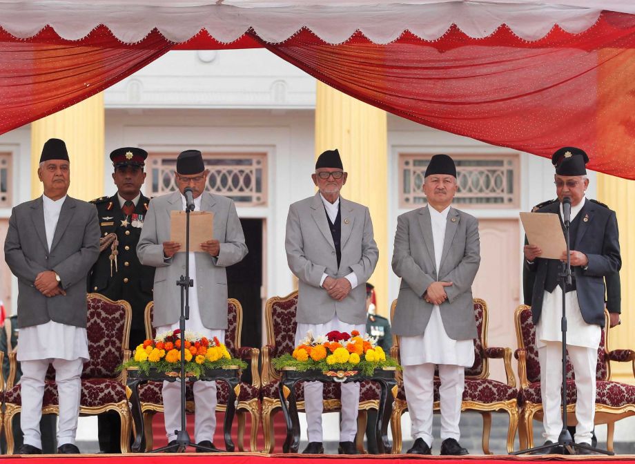 Nepal's President Ram Baran Yadav second left administers the oath of office to newly elected Prime Minister Khadga Prasad Oli right at the Presidential building in Kathmandu Nepal Monday Oct. 12 2015. Nepal's new prime minister took the oath of