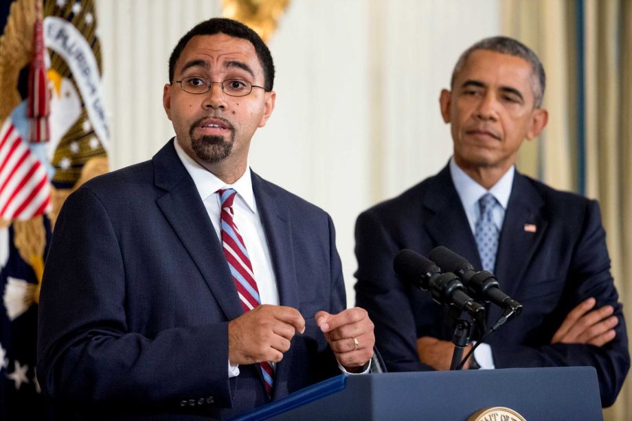 Senior Education Department official John King Jr. left accompanied by President Barack Obama speaks in the State Dining Room of the White House in Washington Friday Oct. 2 2015 after Obama announced that Education Secretary Arne Duncan will be