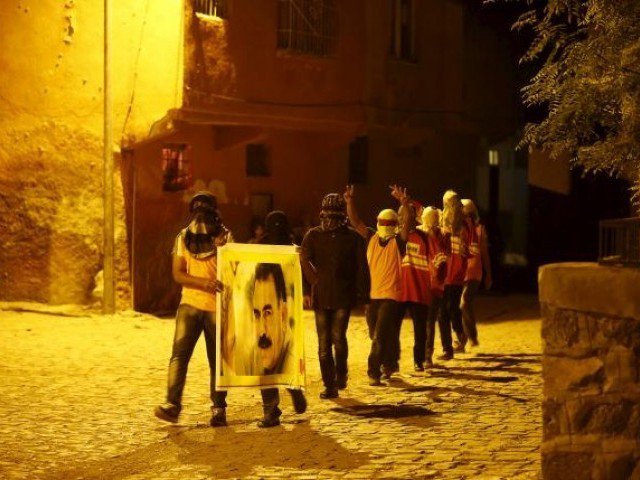 Masked members of YDG-H youth wing of the outlawed Kurdistan Workers Party, shout slogans as they hold a portrait of PKK's jailed leader Abdullah Ocalan in Diyarbakir Turkey