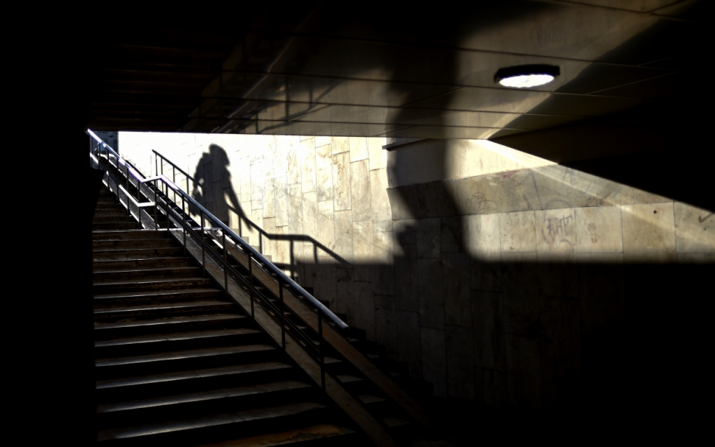 The shadow of a woman is casted on a wall of an underground crossing in Moscow