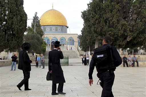 Israeli policeman escort ultra Orthodox Jews as they walk past the Dome of the Rock mosque in Jerusalem's most sensitive holy site a hilltop compound in the Old City that is revered by Jews and Muslims. A new Is