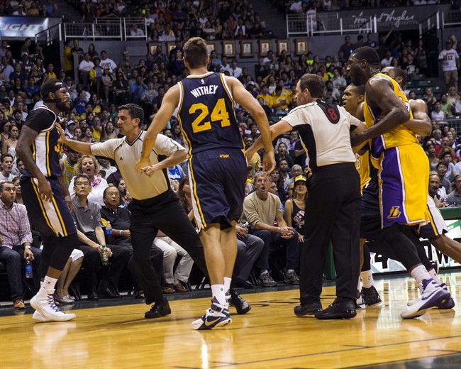 A referee separates Utah Jazz forward Trevor Booker, left and Los Angeles Lakers center Roy Hibbert, far right after an altercation between the players during the second half of an NBA preseason basketball game Tuesday Oct. 6 2015 in Honol