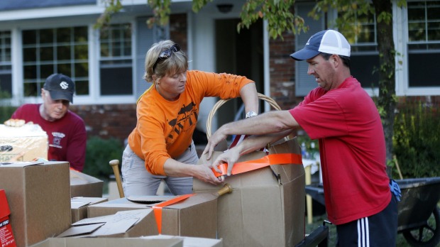 Lucy Mahan and Curtis Player work to secure a friend's belongings on Tuesday after their home was flooded in South Carolina