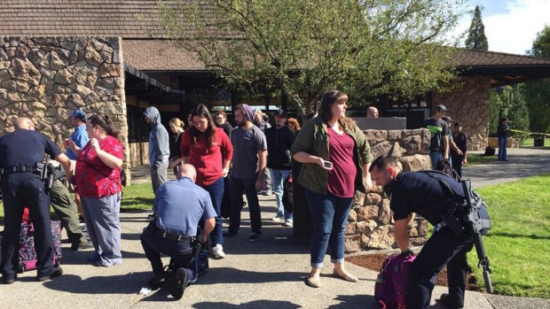 Police officers inspect bags as students and staff are evacuated from Umpqua Community College Oregon