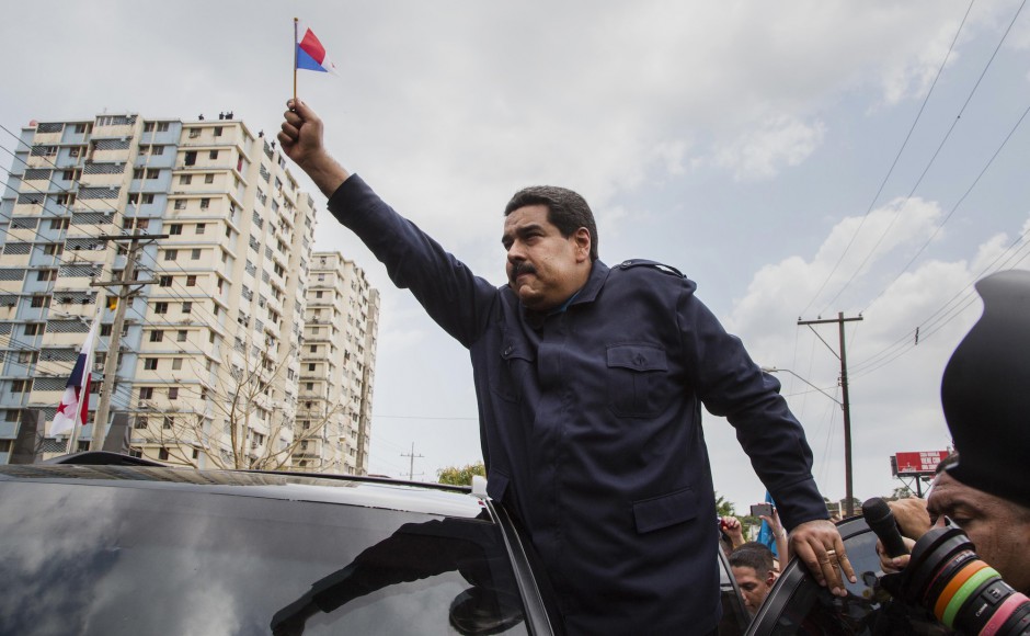 Venezuela's President Nicolás Maduro waves a miniature Panamanian flag from a car while visiting the Chorrillo neighborhood in Panama City