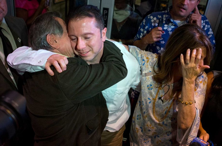 Johnny Hincapie center hugs his father Carlos Hincapie left and mother Maria Hincapie as he leaves a court building Tuesday Oct. 6 2015 in New York. Johnny Hincapie imprisoned for a quarter-century in a notorious tourist killing was granted a