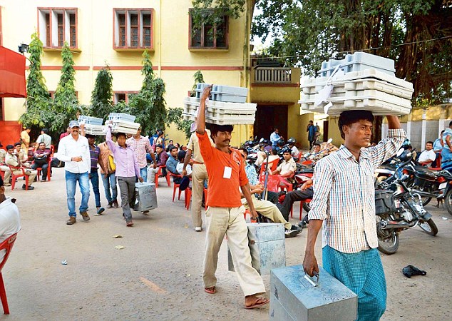 Men carry the voting machines that will help decide Bihar's political future as the state polls continue