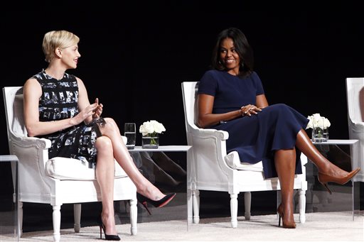 Actress Charlize Theron left applauds first lady Michelle Obama during a panel discussion entitled The Power of an Educated Girl at the Apollo Theater Tuesday Sept. 29 2015 in New York