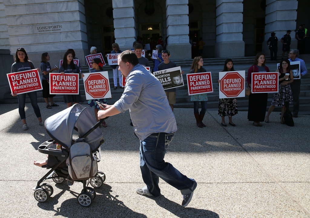 WASHINGTON DC- SEPTEMBER 16 Protesters hold signs protesting Planned Parenthood in front of the Longworth House Office Building on Capitol Hill