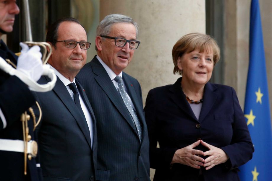 French President Francois Hollande European Commission President Jean Claude Junker and German Chancellor Angela Merkel pose as they arrive for the France Germany Online Conference at the Elysee Palace in Paris Tuesday Oct 27 2015. German Chancellor