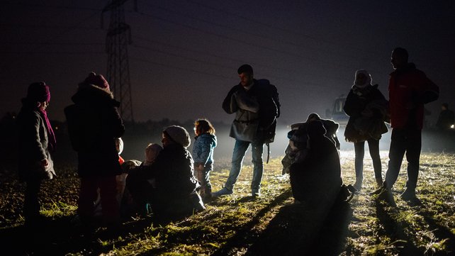 Migrants and refugees rest as they wait to board buses to go to a refugee center after crossing Croatian Slovenian border in Rigonce