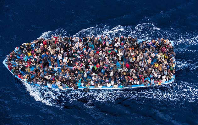 Migrants approaching Italian coasts just before getting rescued by the Italian navy in June 2014