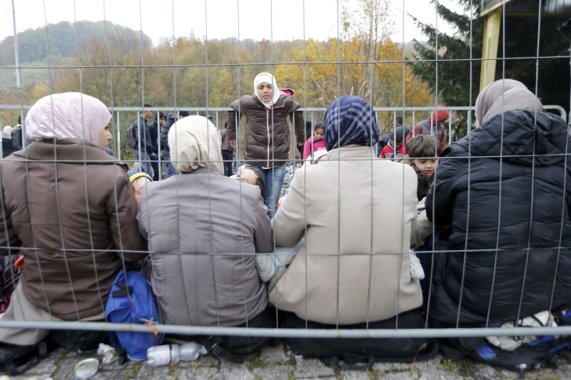 Migrants wait to cross the border into Spielfeld in Austria from the village of Sentilj Slovenia