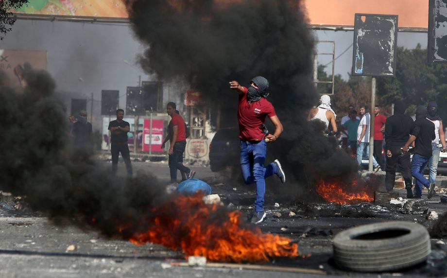 Palestinian demonstrator hurls rocks at Israeli border guards in the West Bank city of Nablus