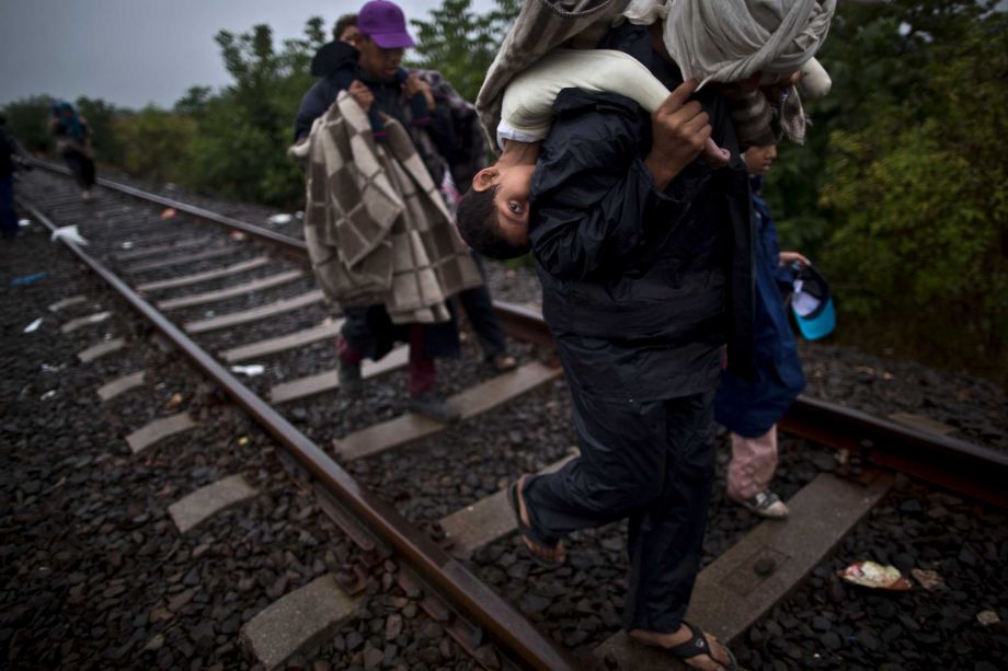 Bara'ah Alhammadi 10 a Syrian migrant is carried on the back of her father as they make their way along a railway track after crossing the Serbian Hungarian border near Roszke southern Hungary. Tens of thousands