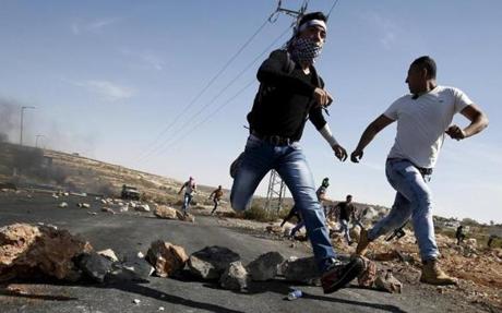 Palestinians ran for cover during clashes with Israeli troops Sunday near a Jewish settlement in the West Bank