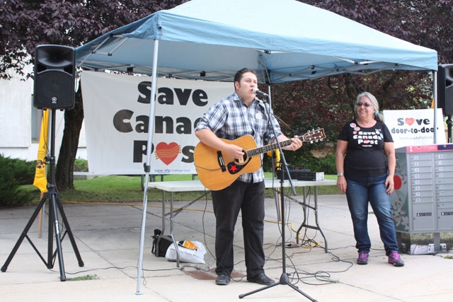 Local CUPW 790 president Brenda Muscoby Yanke stands beside a singing CUPW President Mike Palecek during a rally to protest pending cuts to Canada Post in August at the City of Nelson courtyard. Canada Post put the brakes on changes Monday. — Brendan Qu