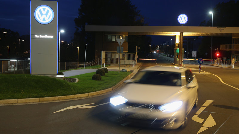 Volkswagen says the fallout from its diesel emissions scandal is still becoming clear as it reports a large quarterly loss. A car departs from Volkswagen's factory and company headquarters in Wolfsburg Germany