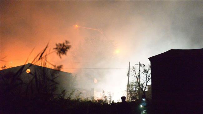 Fire and smoke rise at the site of an explosion at a warehouse in in Tianjin China