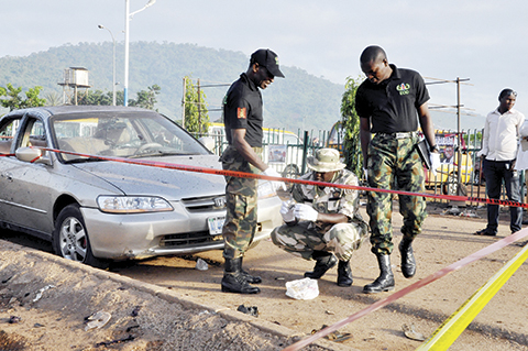Soldiers gather at the site of a bomb explosion in Abuja Nigeria Saturday Oct. 3 2015. Multiple bombs detonated in two locations killing at least 15 people the National Emergency Management Agency said Saturday although no group has claimed respons